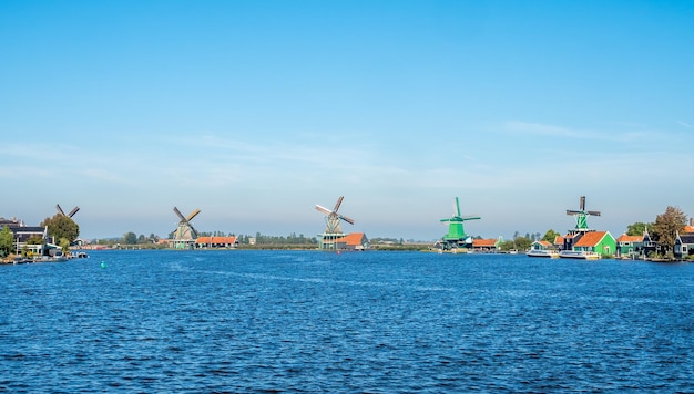 Zaan Schans es una atracción popular en los Países Bajos, tiene una colección de molinos de viento y casas históricas bien conservadas, esta vista desde el puente bajo el cielo azul