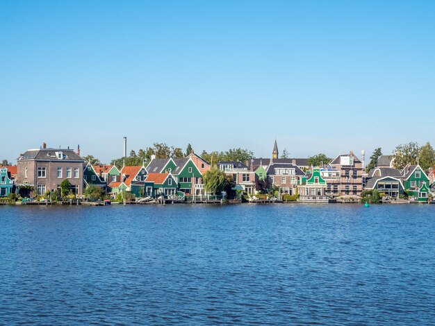 Zaan Schans ist eine beliebte Sehenswürdigkeit in den Niederlanden, hat eine Sammlung gut erhaltener historischer Windmühlen und Häuser, diese Ansicht von der Brücke unter blauem Himmel