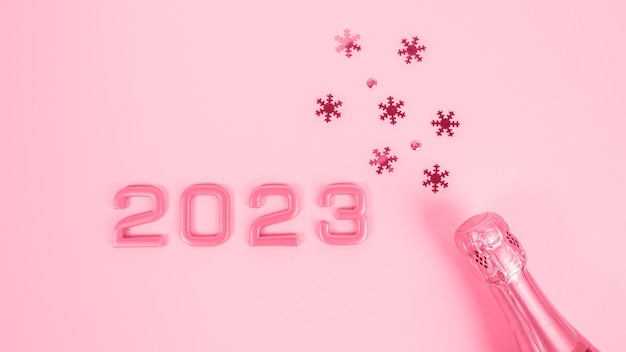 Zahlen 2023 und eine Flasche Champagner mit Konfetti. Neujahrsfeier