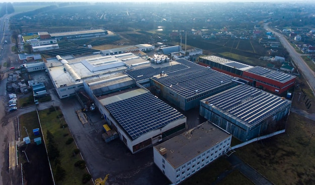 Zahlreiche Sonnenkollektoren auf dem Industriegebäude montiert Großzügige Dachfläche zur Gewinnung sauberer Energie nutzen Blick auf die ländliche Umgebung im Hintergrund