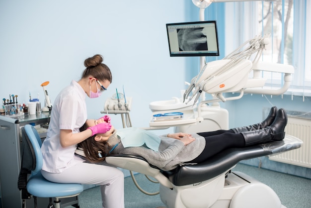 Zahnärztin mit zahnärztlichen Werkzeugen - Spiegel und Sonde zur Behandlung von Patientenzähnen in der Zahnklinik. Konzept für Medizin, Zahnmedizin und Gesundheitswesen. Zahnärztliche Ausrüstung