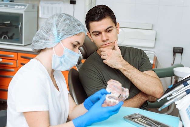 Zahnärztin zeigt die bevorstehende Behandlung