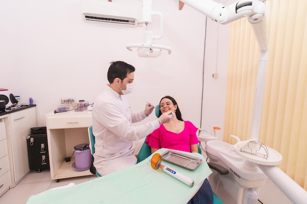 Zahnarzt arbeitet an seiner weiblichen Patientin in seiner Zahnarztpraxis.