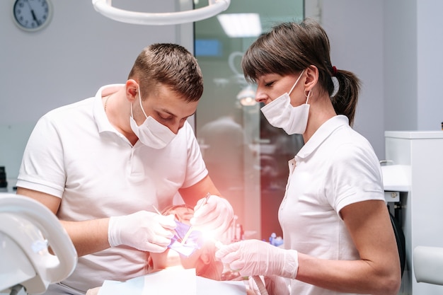 Zahnarzt, der eine Patientin in der Stomatologie heilt.