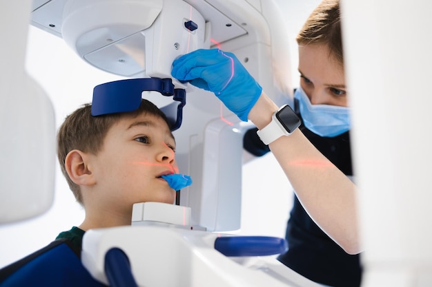 Zahnarzt, der einem kleinen Jungen mit einem modernen Röntgengerät eine Panorama-Zahnröntgenaufnahme macht