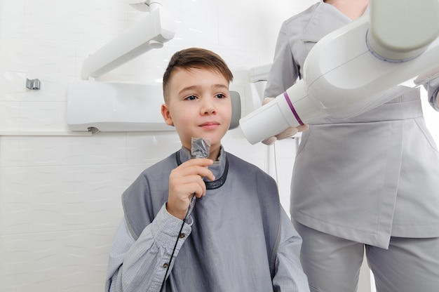 Foto zahnarzt machen kiefer röntgenbild für kleinen jungen in der zahnklinik