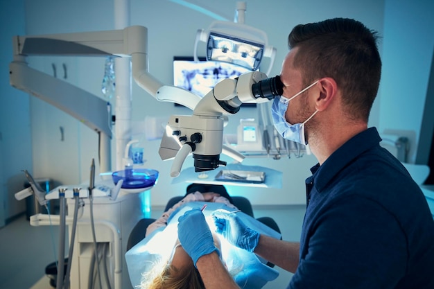 Zahnarzt mit Maske untersucht Mädchen in der Klinik