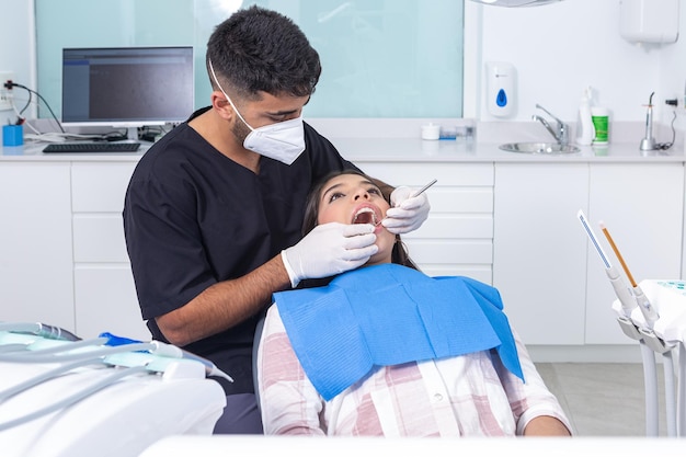 Zahnarzt überprüft die Zähne eines jugendlichen Patienten