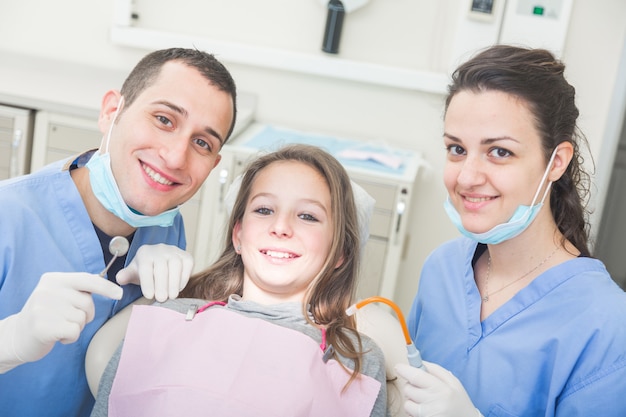 Zahnarzt- und Zahnarzthelferporträt mit jungem Patienten