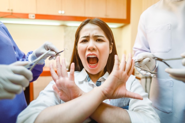 Zahnarzt untersucht Zahnpatienten in der Klinik auf bessere Zahngesundheit und ein strahlendes LächelnDer Patient hat Angst, Weisheitszähne zu entfernenZahnwerkzeuge und -ausrüstung