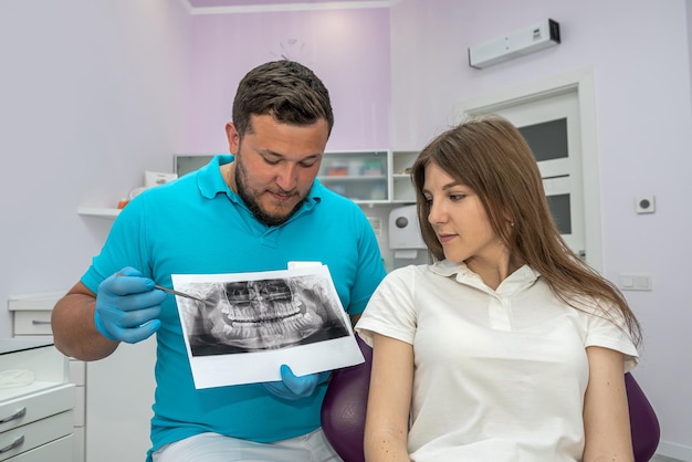 Zahnarzt zeigt ein Bild des Kiefers eines jungen Patienten