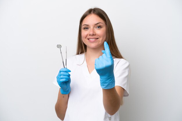 Zahnarztfrau, die Werkzeuge lokalisiert auf weißem Hintergrund hält und kommende Geste tut
