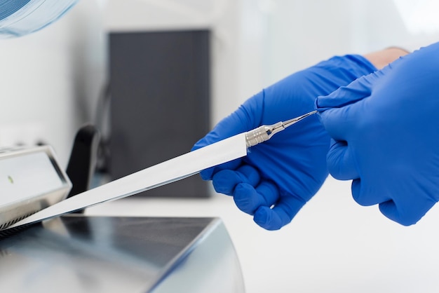 Zahnarzthelferin verpackt zahnärztliche Geräte nach dem Autoklaven in Sterilisationsbeutel aus Kunststoff