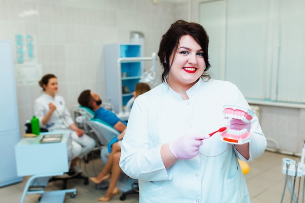 Zahnarztklinik. Porträt eines professionellen Zahnarztes vor dem Hintergrund eines Arbeitsteams von Ärzten. Konzept der medizinischen Ausbildung und Krankenversicherung.