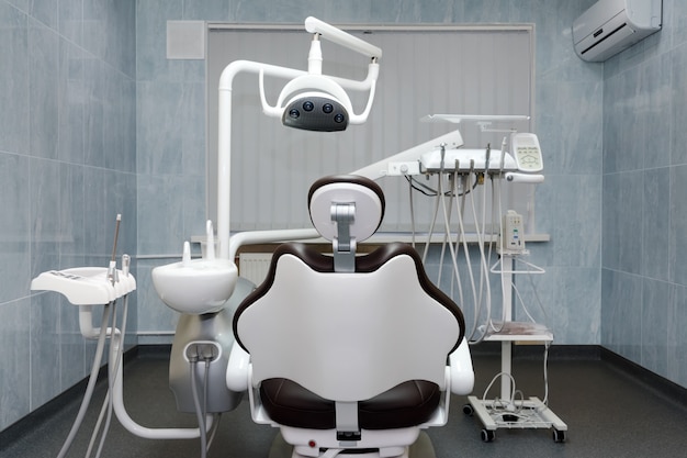 Zahnarztpraxis. Moderner Zahnarztschrank. Zahnärztliche Instrumente und Werkzeuge in der modernen Klinik, professioneller Zahnarztstuhl, der darauf wartet, vom Kieferorthopäden verwendet zu werden