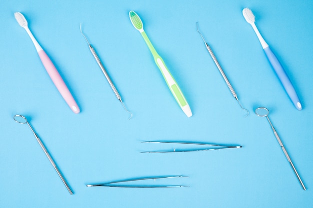 Zahnmedizinischer Werkzeuggebrauch für Zahnarzt auf dem blauen Hintergrund, flache Lage, Draufsicht.