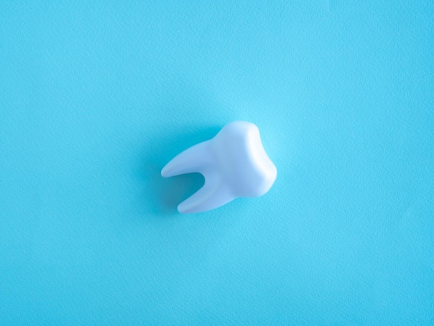 Zahnmedizinisches Konzept Zahn auf blauem Hintergrund Platz für Ihren Text
