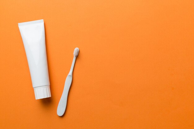 Zahnpasta und Zahnbürste Draufsicht mit Kopierbereich auf farbigem Hintergrund Flach liegend Zahnhygiene Mundpflegeprodukte auf hellem Hintergrund Körperpflegekonzept