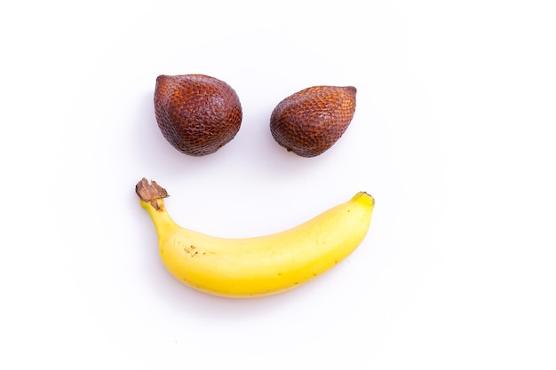 Zalacca y plátano formando una cara sonriente, aislado de un blanco