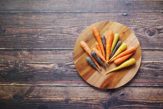 Zanahoria de colores mezclados en una tabla de cortar vista superior