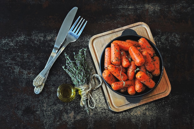 Zanahorias baby al horno con hierbas en una sartén de hierro fundido.