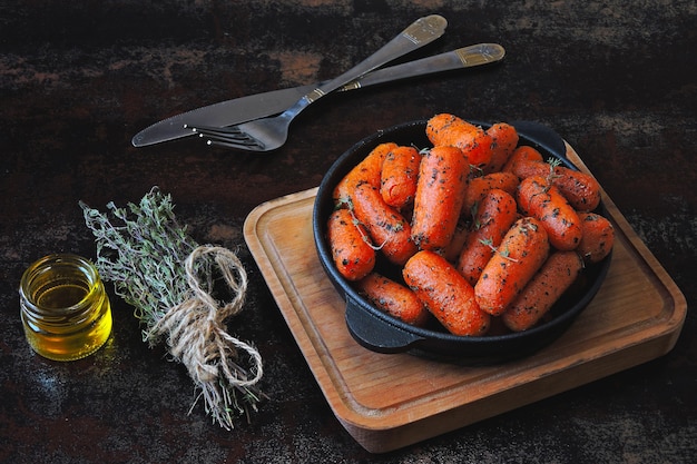 Zanahorias baby al horno con hierbas en una sartén de hierro fundido.