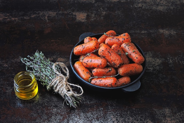 Zanahorias baby al horno con hierbas en una sartén de hierro fundido.