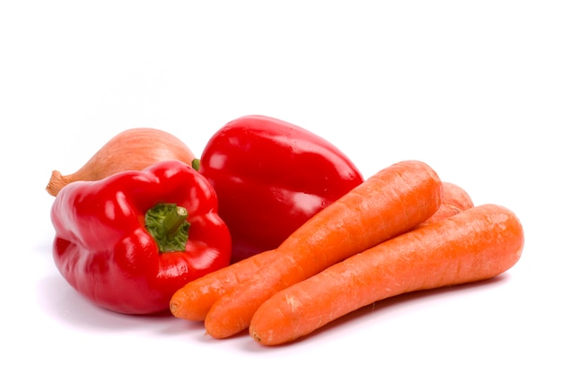 Zanahorias, cebolla y pimentón rojo sobre fondo blanco