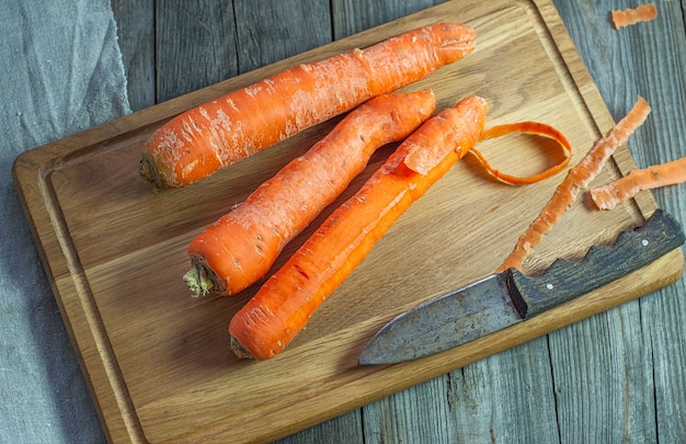 Zanahorias enteras en una tabla de cortar de cocina