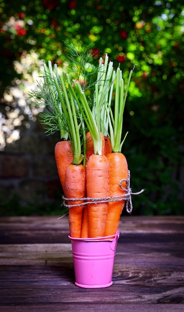 Zanahorias frescas atadas con una cuerda en una mesa marrón