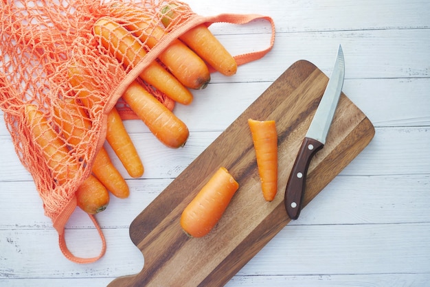 Zanahorias frescas sobre una tabla de cortar en la mesa