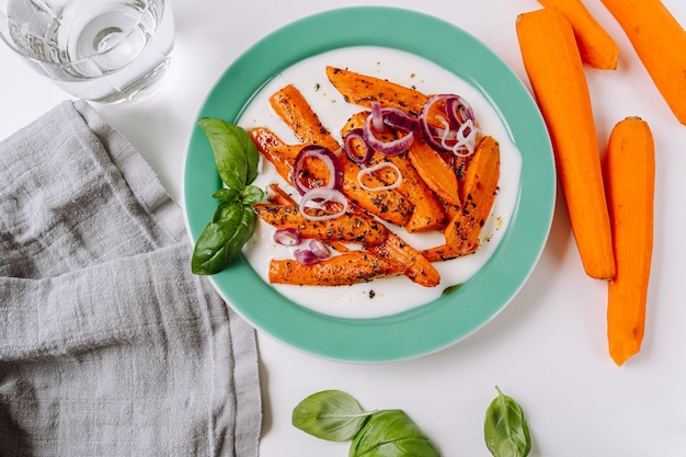 zanahorias fritas con cebolla roja y crema de yogur feta