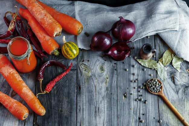 Zanahorias naranjas frescas maduras con jugo fresco en un frasco pequeño