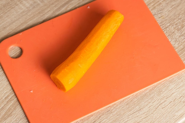 Foto zanahorias peladas en una tabla para cortar