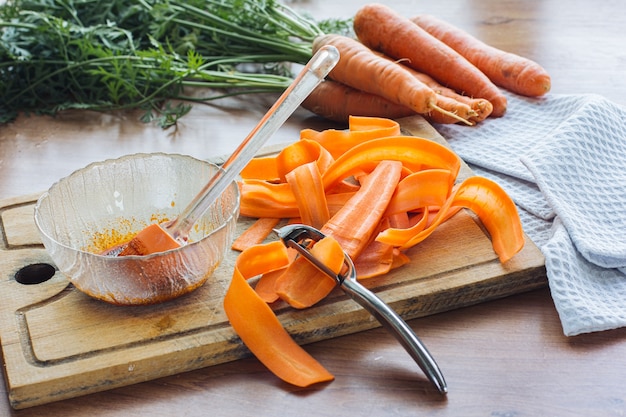 Foto las zanahorias en rodajas están sobre la mesa para cocinar tocino de zanahoria. comida vegetariana, sustituto de carne, proteína vegetal.