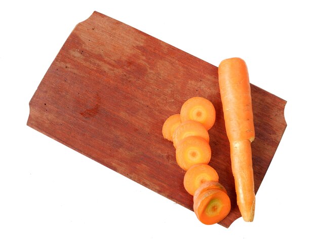 Zanahorias en una tabla de cortar de madera aislado sobre un fondo blanco.