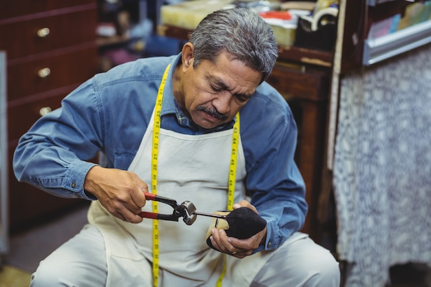 Zapatero martillando en un zapato