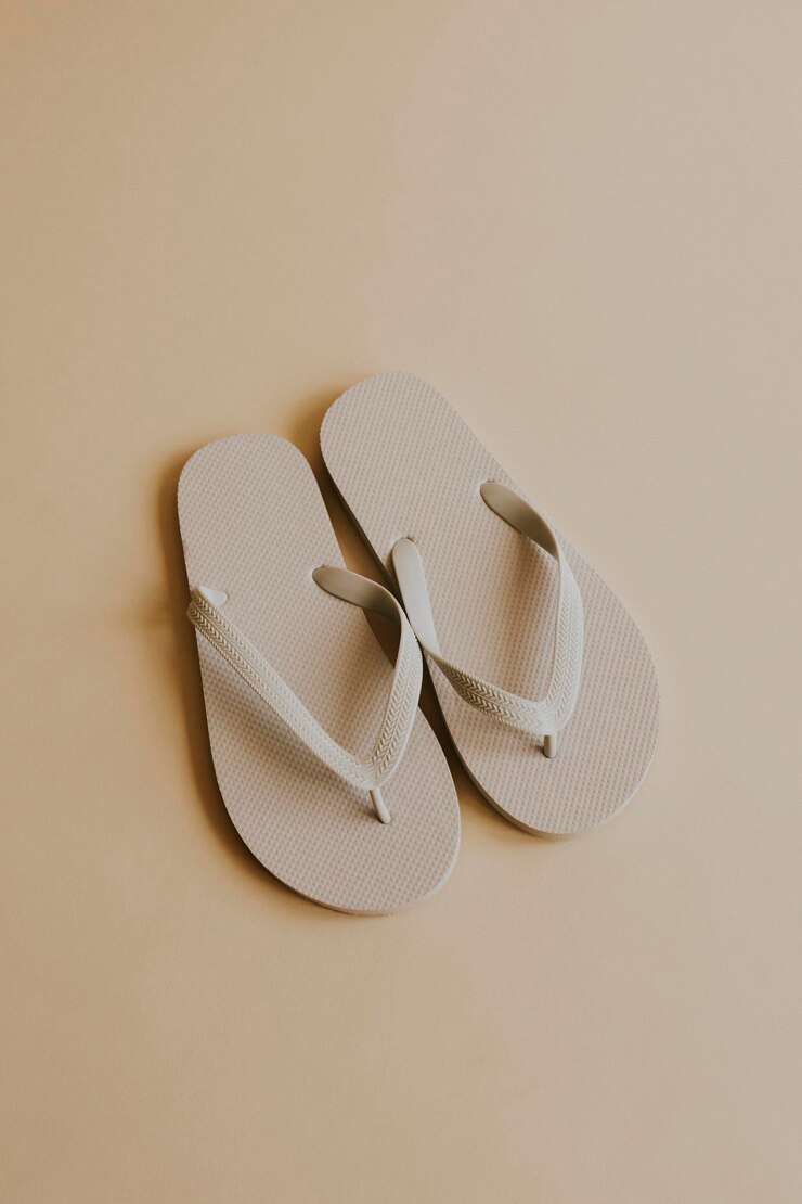 Zapatilla flip flop blanco roto sobre beige