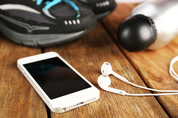 Zapatillas y auriculares en primer plano de la mesa de madera