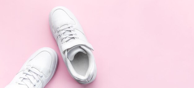 Zapatillas blancas sobre un fondo rosa