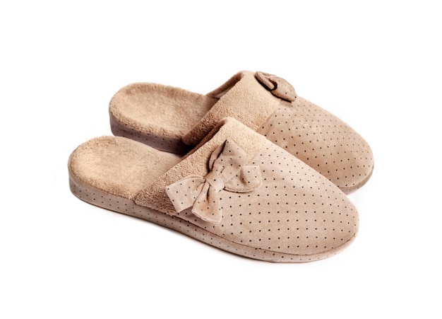 Zapatillas de casa beige aisladas sobre superficie blanca