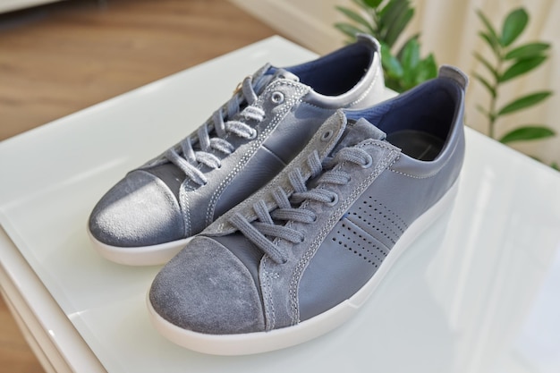 Zapatillas de cuero gris de moda para hombre, diseño casual. Nuevo par de zapatos en casa, compras en línea, rebajas de temporada, tendencias de calzado masculino.