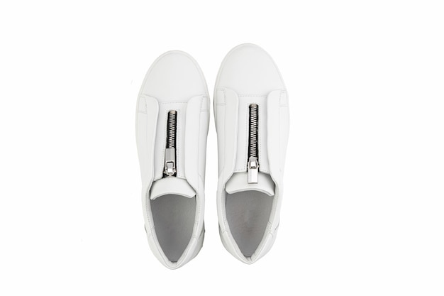 Zapatillas de deporte de cuero blanco con cremallera en la parte delantera en lugar de cordones sobre fondo blanco Estilo casual de mujer Vista superior Zapatos de moda
