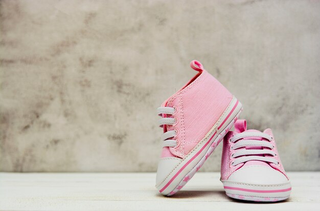 Zapatillas de deporte rosadas de la niña, zapatos deportivos cerca Newbord, maternidad, concepto de embarazo con espacio de copia.