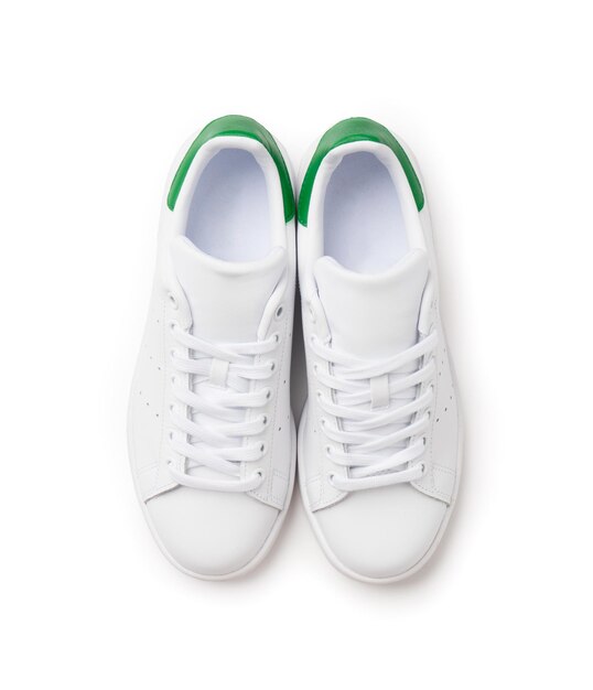 Zapatillas deportivas casuales blancas con encaje en cuero con detalles de diseño verde Zapatillas nuevas sobre un fondo blanco