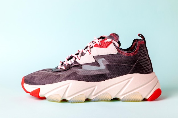 zapatillas deportivas de moda para mujeres negras con acentos rojos sobre un fondo azul