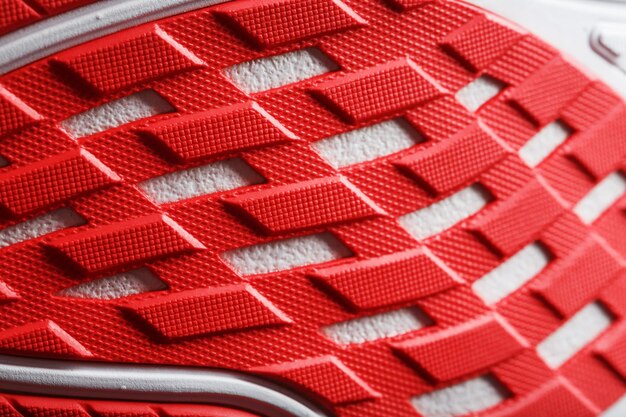 Zapatillas deportivas con suela roja sobre fondo negro.