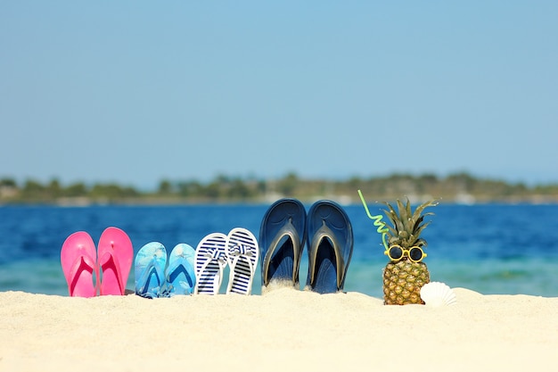 Zapatillas familiares en la arena de la playa en verano