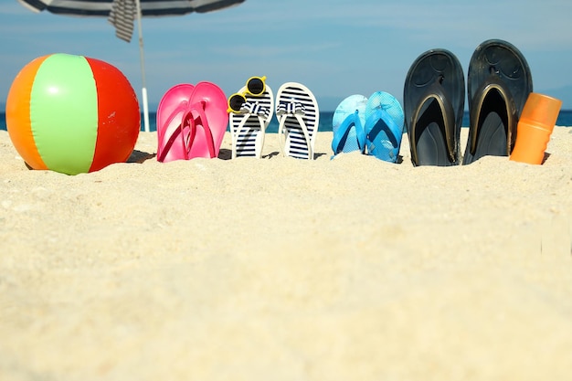 Zapatillas familiares en la arena de la playa.