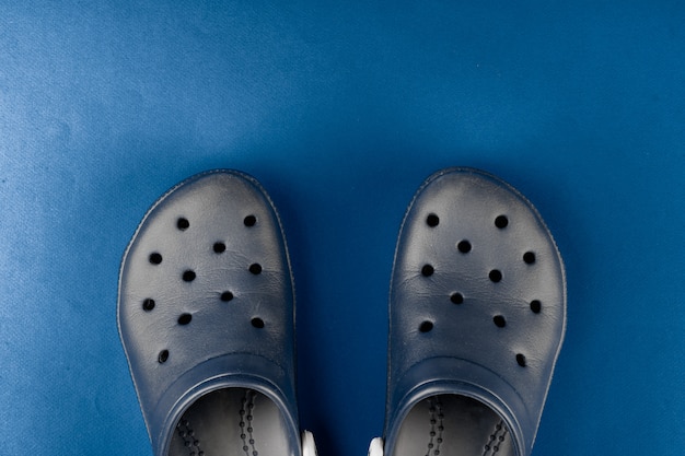 Zapatillas de goma sobre fondo azul cl sico vista superior Foto